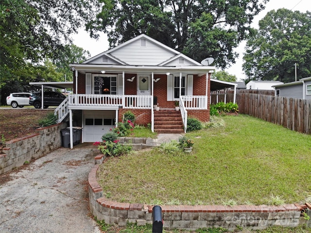 view of front of home featuring a porch, a garage, a carport, and a front lawn