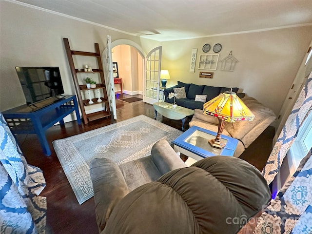 living room with dark wood-type flooring, ornamental molding, and french doors