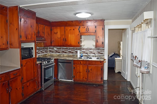 kitchen featuring dark hardwood / wood-style flooring, sink, tasteful backsplash, and appliances with stainless steel finishes