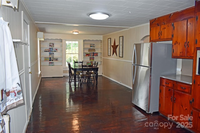 kitchen featuring stainless steel refrigerator, dark wood-type flooring, and built in features