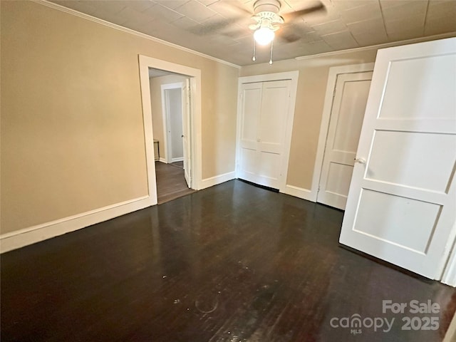 interior space featuring ceiling fan, ornamental molding, and dark hardwood / wood-style flooring