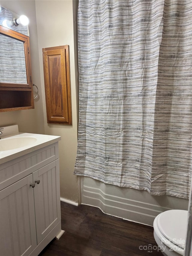 full bathroom featuring hardwood / wood-style flooring, vanity, toilet, and shower / bath combo with shower curtain