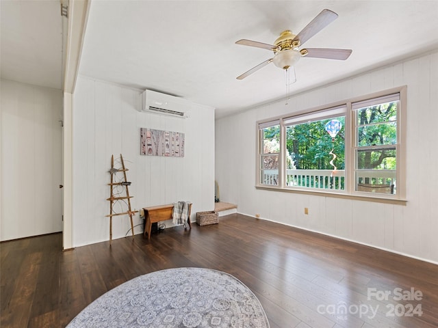 living area featuring ceiling fan, wooden walls, dark hardwood / wood-style flooring, and a wall mounted AC