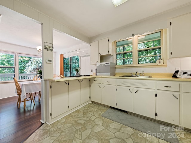 kitchen featuring a healthy amount of sunlight, sink, light hardwood / wood-style flooring, and white cabinets