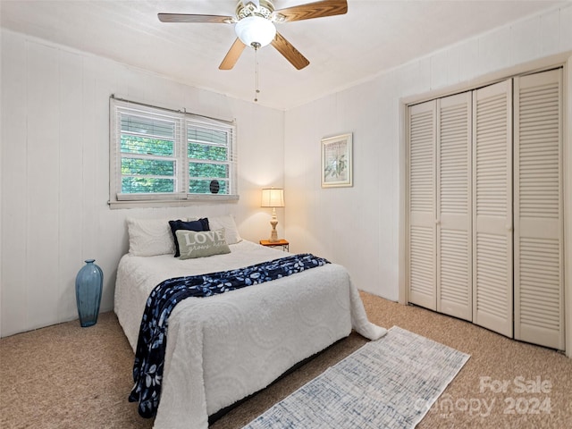 carpeted bedroom featuring ceiling fan and a closet