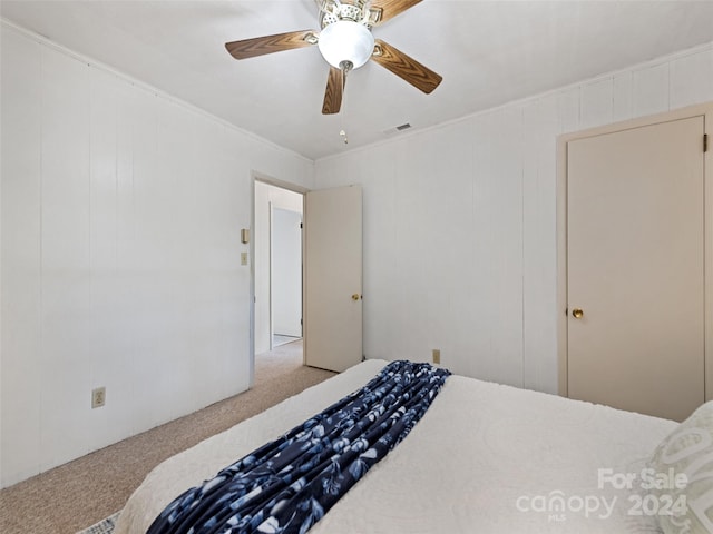 carpeted bedroom featuring crown molding and ceiling fan