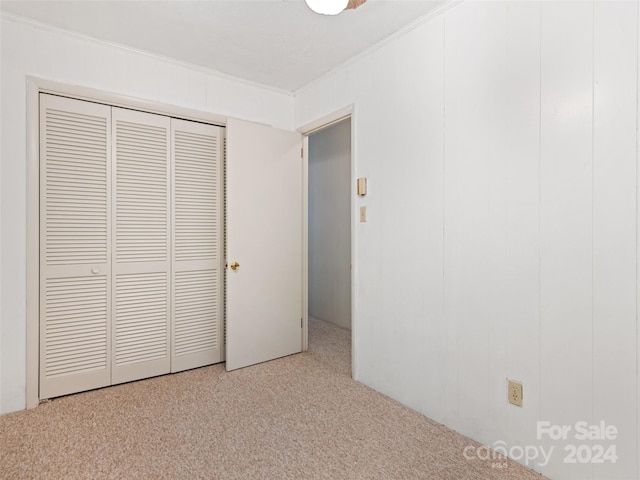 unfurnished bedroom featuring ornamental molding and light colored carpet