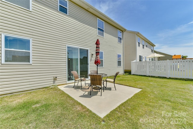 rear view of property with a yard and a patio