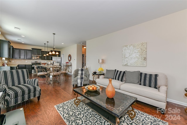 living room featuring dark wood-type flooring and a notable chandelier