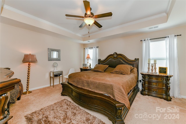 bedroom with light carpet, ceiling fan, a raised ceiling, and crown molding