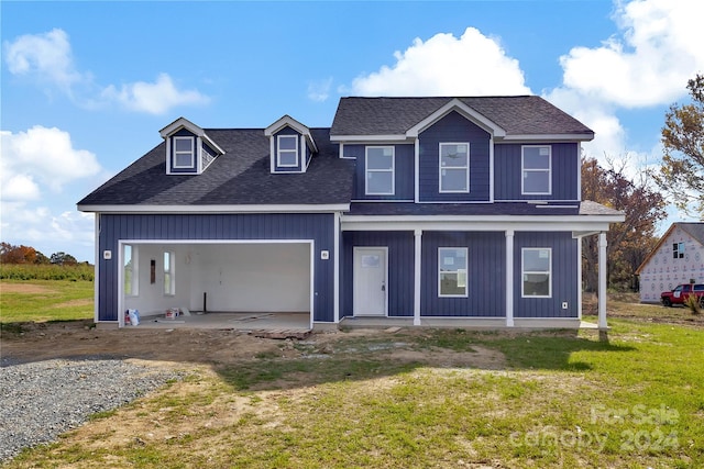 view of front of home featuring a front yard, a porch, and a garage