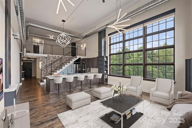 living room featuring a high ceiling, an inviting chandelier, and dark hardwood / wood-style floors