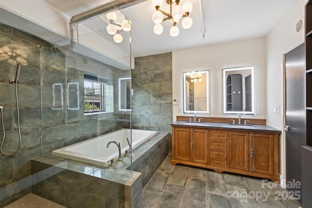 bathroom with an inviting chandelier, a relaxing tiled tub, and vanity