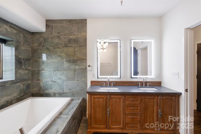 bathroom featuring tiled bath and vanity