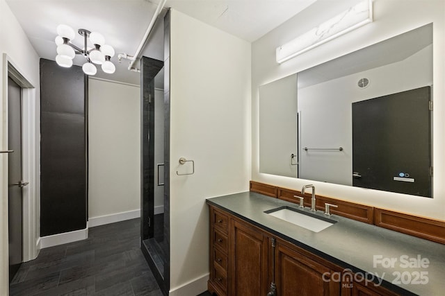 bathroom featuring an enclosed shower, vanity, and an inviting chandelier