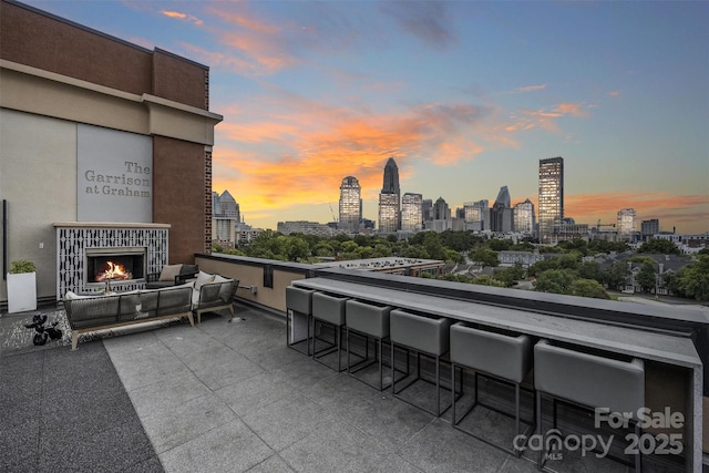 patio terrace at dusk featuring an outdoor bar and an outdoor hangout area