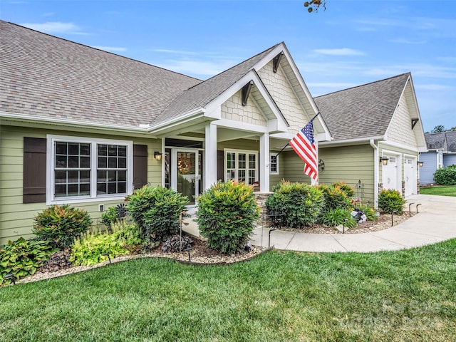 craftsman inspired home featuring a front yard and a garage