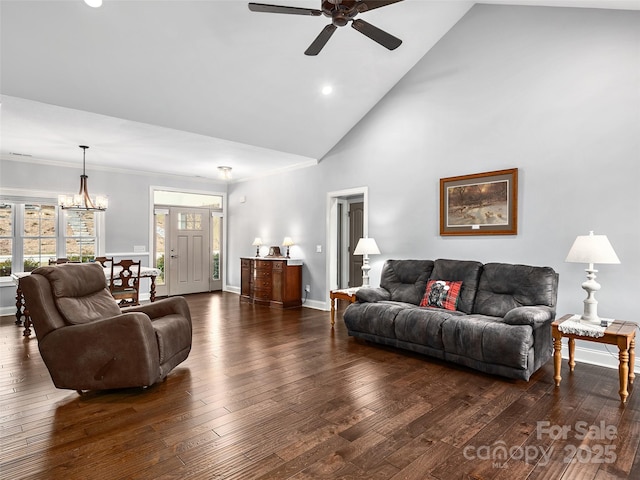 living room with ceiling fan with notable chandelier, dark hardwood / wood-style floors, and high vaulted ceiling