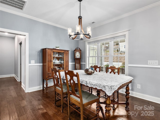 dining room featuring an inviting chandelier, crown molding, and dark wood-type flooring