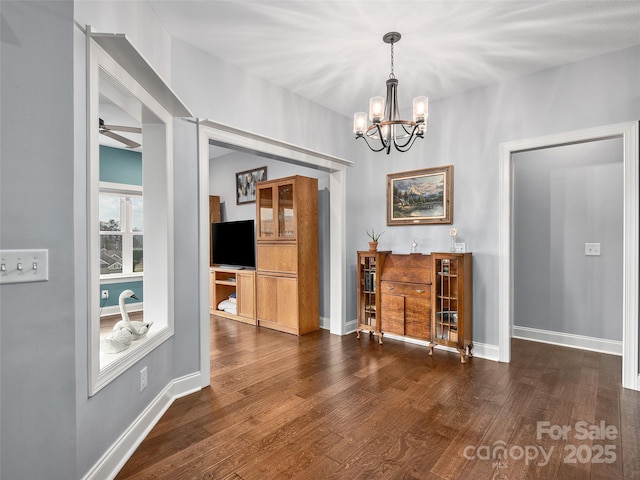 unfurnished dining area featuring dark hardwood / wood-style floors and ceiling fan with notable chandelier