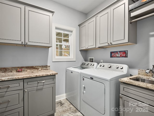 washroom with sink, cabinets, and washing machine and clothes dryer