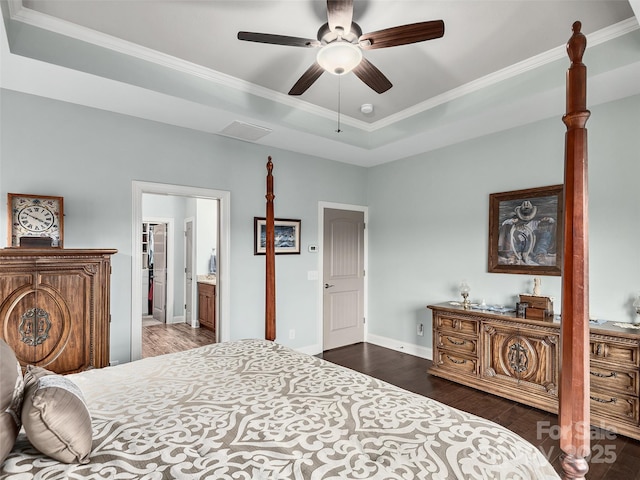 bedroom with ornamental molding, a spacious closet, ceiling fan, a tray ceiling, and dark wood-type flooring