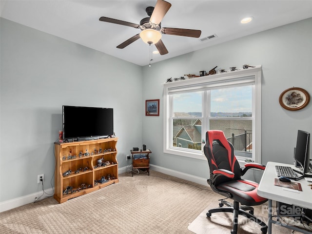 carpeted office space featuring ceiling fan