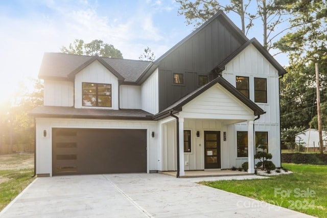 modern farmhouse style home with a front yard and a garage