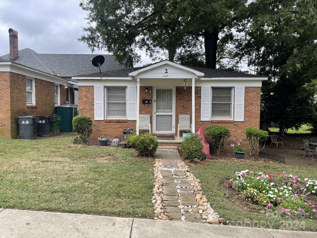 1127 Allen St, Charlotte, NC 28205 - view of front of home with brick siding, a front yard, and a chimney