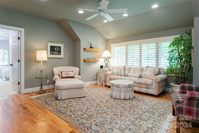 living room with ceiling fan, light wood-type flooring, vaulted ceiling, and a healthy amount of sunlight