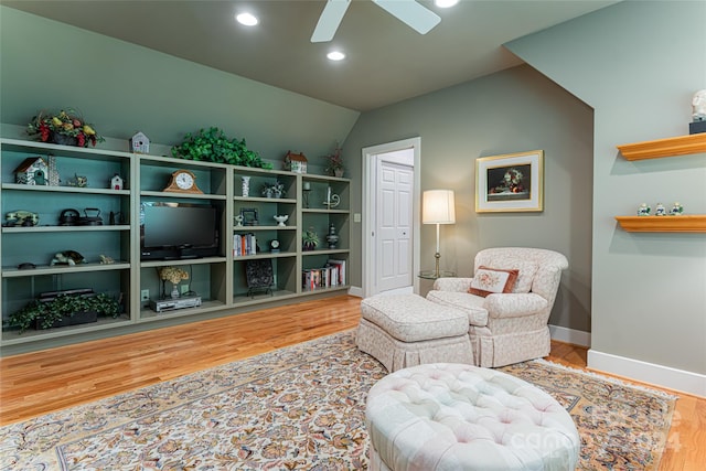 living area featuring ceiling fan, hardwood / wood-style flooring, and lofted ceiling