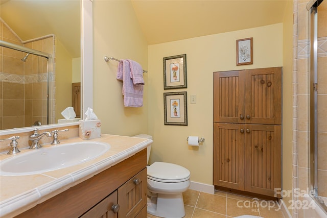 bathroom featuring vaulted ceiling, vanity, an enclosed shower, toilet, and tile patterned floors