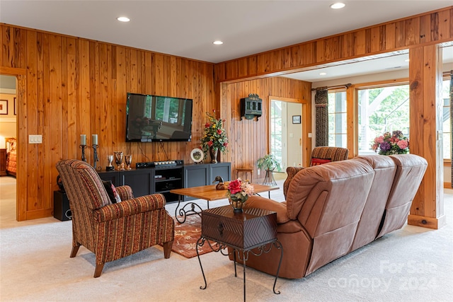 carpeted living room with wooden walls