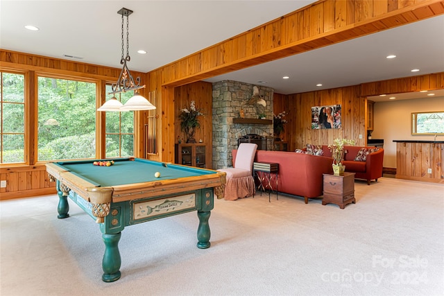 recreation room with wooden walls, pool table, carpet flooring, and a stone fireplace