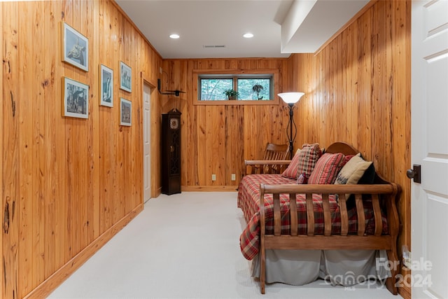 carpeted bedroom featuring wood walls