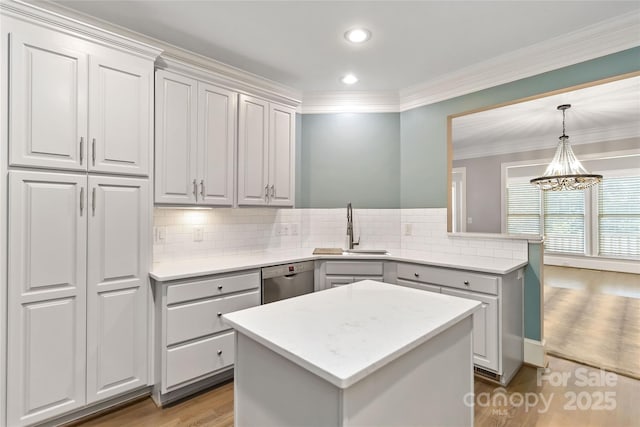 kitchen featuring sink, gray cabinetry, hardwood / wood-style floors, a kitchen island, and stainless steel dishwasher