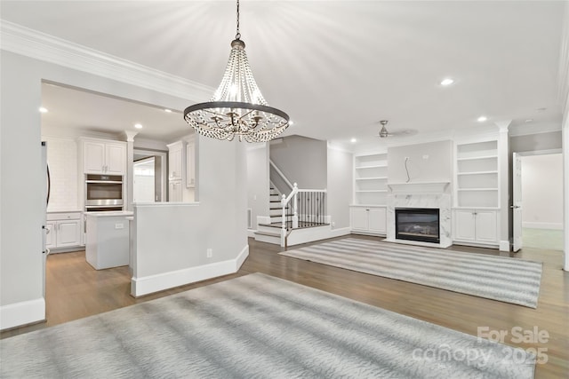 unfurnished living room featuring crown molding, a high end fireplace, and light hardwood / wood-style floors