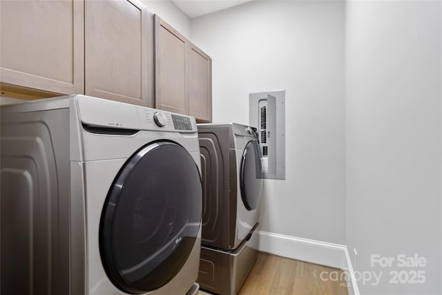 laundry area featuring cabinets, independent washer and dryer, and light hardwood / wood-style flooring