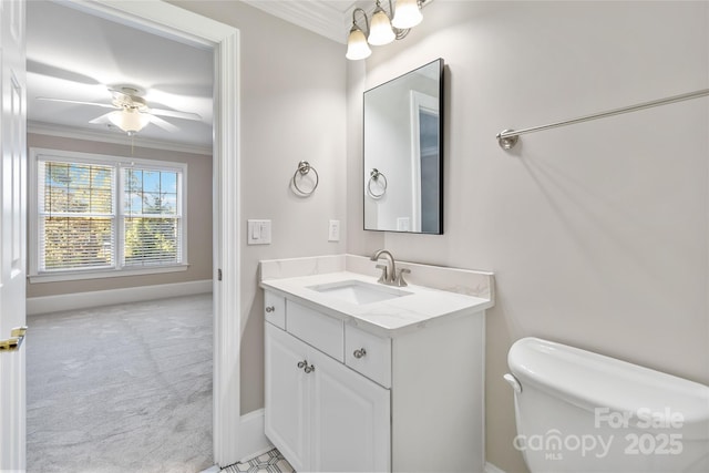 bathroom with crown molding, ceiling fan, vanity, and toilet