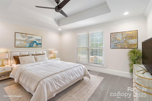 bedroom with crown molding, ceiling fan, dark carpet, and a tray ceiling