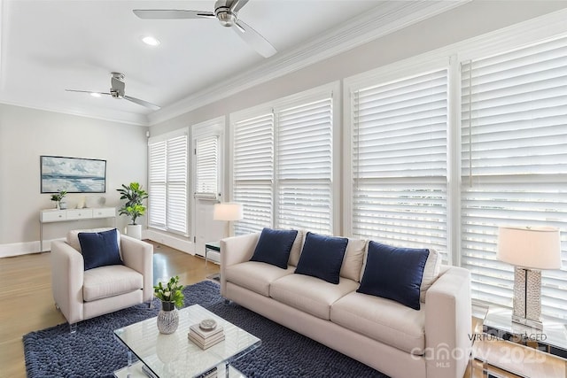 living room with hardwood / wood-style flooring, crown molding, and ceiling fan