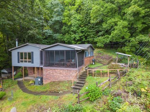 back of house with central air condition unit and a sunroom