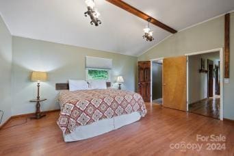 bedroom with vaulted ceiling with beams and wood-type flooring