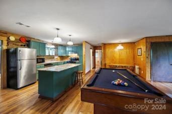 rec room featuring billiards, light hardwood / wood-style flooring, and wooden walls