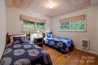 bedroom featuring wood ceiling, hardwood / wood-style flooring, ornamental molding, and heating unit