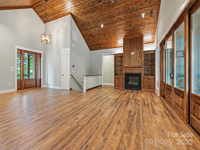 unfurnished living room with high vaulted ceiling, hardwood / wood-style flooring, a fireplace, a notable chandelier, and wood ceiling