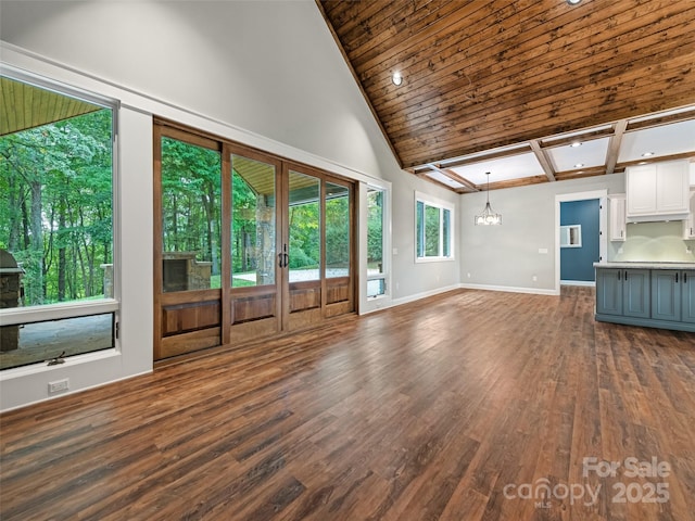 unfurnished living room with a chandelier and dark wood-type flooring