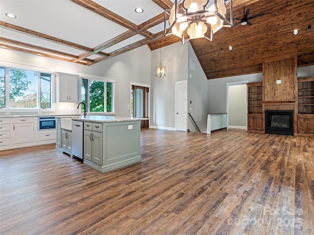 kitchen with a center island, sink, appliances with stainless steel finishes, decorative light fixtures, and dark hardwood / wood-style flooring