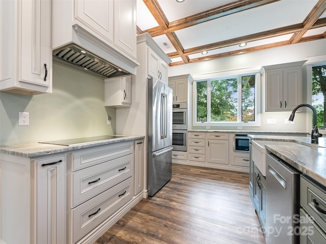 kitchen featuring sink, coffered ceiling, dark hardwood / wood-style flooring, custom exhaust hood, and appliances with stainless steel finishes