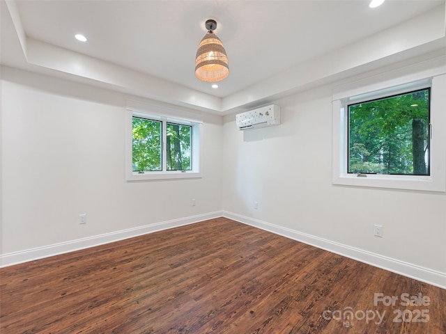 spare room featuring a wall mounted AC and dark wood-type flooring